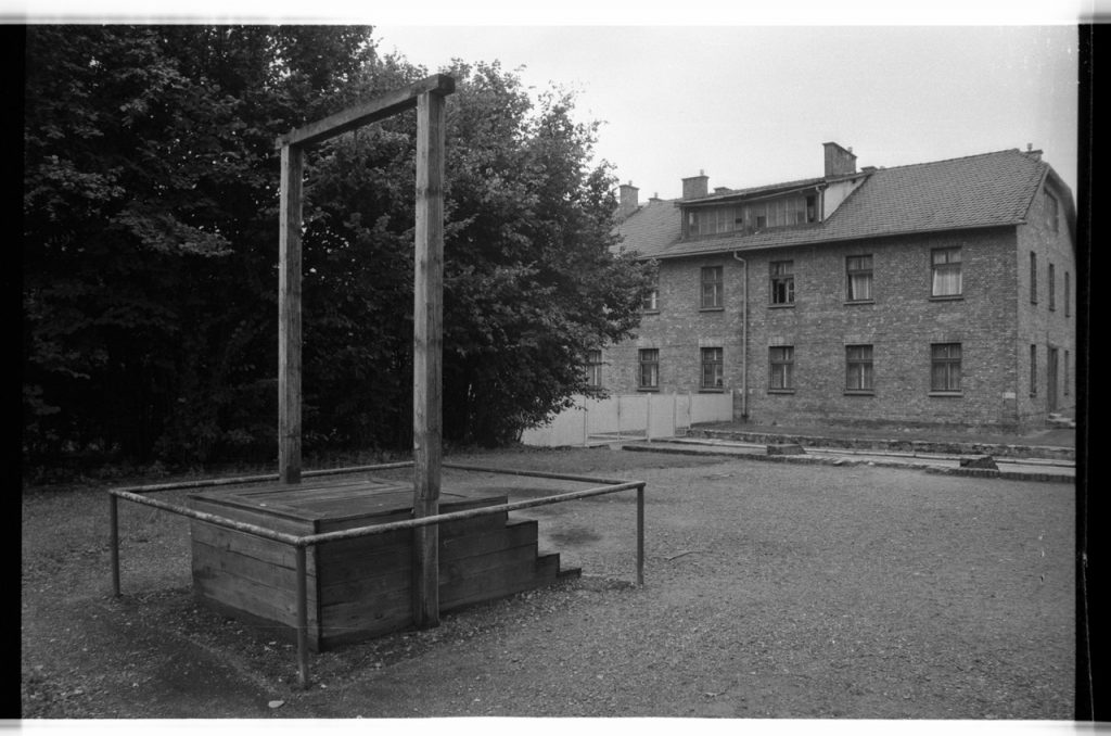 B/W photo a hanging area. Wooden platform and a brick building in background.  Nikon D70 Film Camera 2004 - Negative Scan from Nikon COOLSCAN V ED 2008
