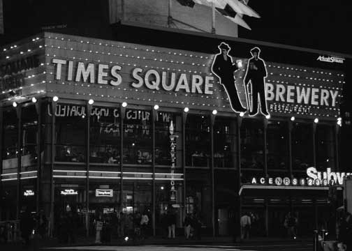 B/W photo of night shot. "Times Square Brewery" on the top of building.
